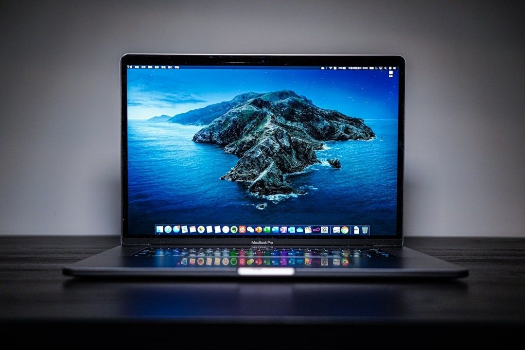 MacBook Pro med macOS-skrivbord och kustlandskap som bakgrund