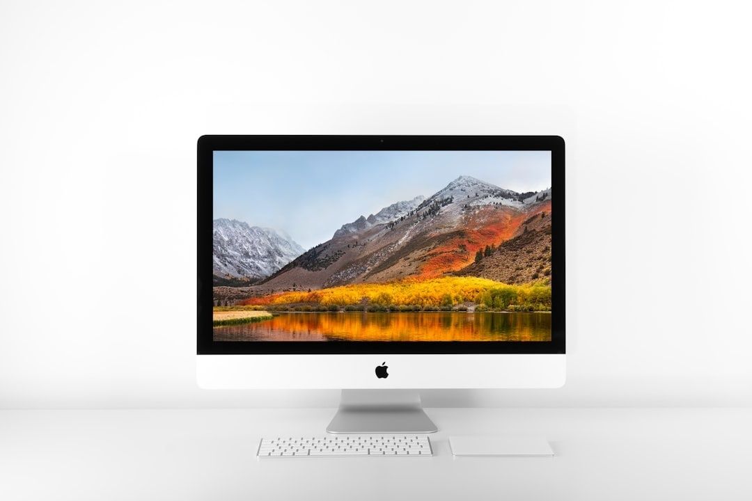 iMac med färgstarkt bergslandskap på skärmen, tangentbord och styrplatta